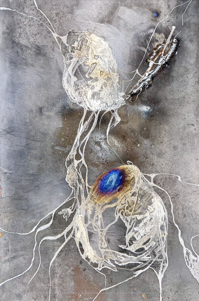 Lesions by Priscilla Smith: two figures traced in fine white lines across a sheet of welded and etched steel, one marked by a blue heat-tinted bloom
