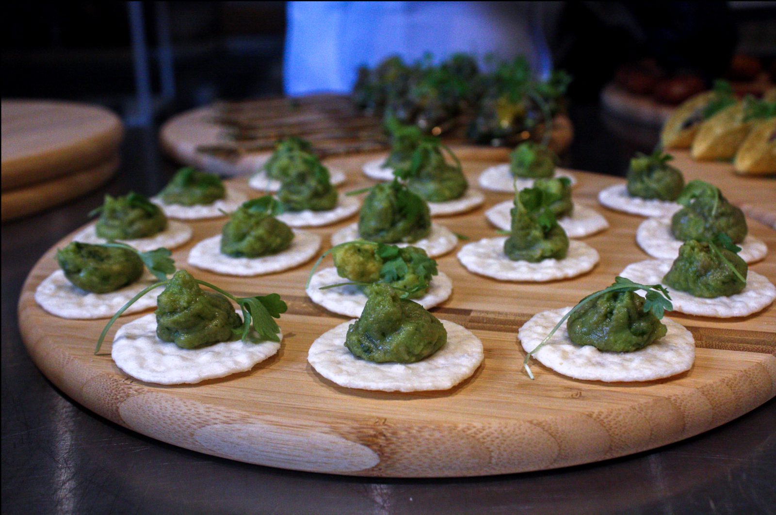 Smashed avocado on round crackers, finished with parsley
